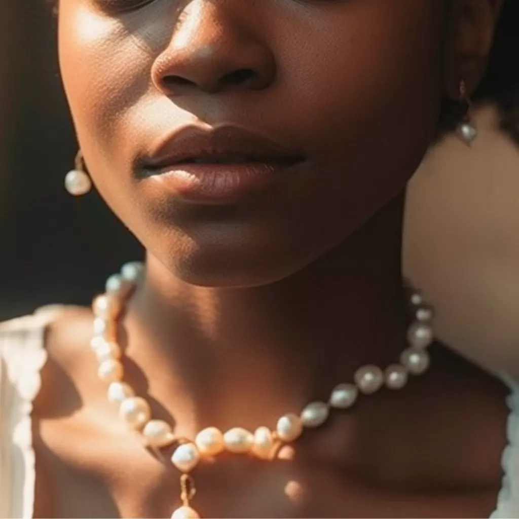 White Crystals: Close up photo of a person wearing Pearls as a necklace and Moonstone as earrings.