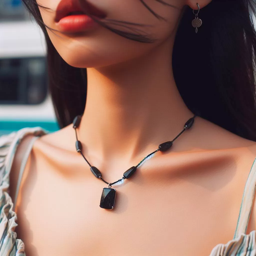 Close up photo of a person wearing a black tourmaline necklace